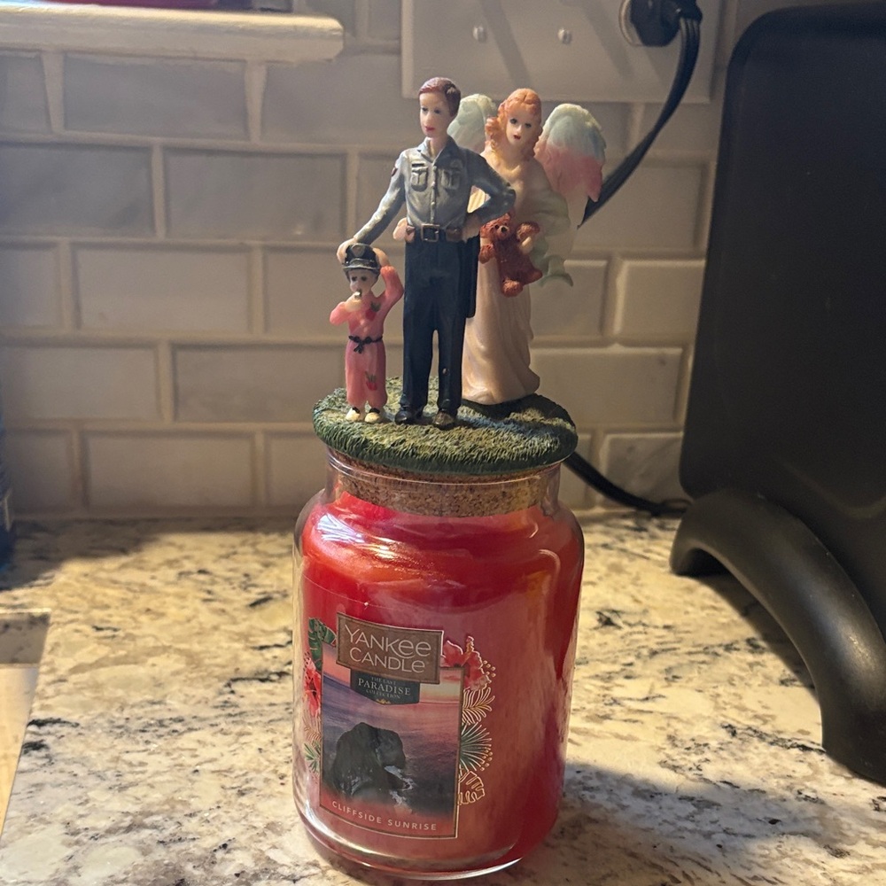 Yankee Candle Red Paradise Sunrise with an Angel in back of LEO and Child